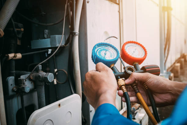 Technician is checking air conditioner refrigerant leak. Residential furnace maintenance service in Flat Rock Michigan